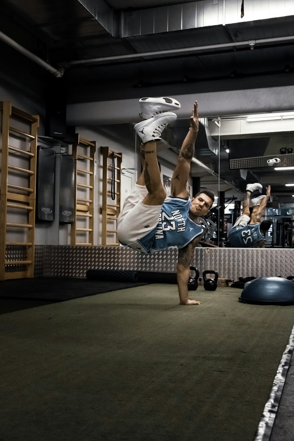 man wearing short and jersey in hand stand