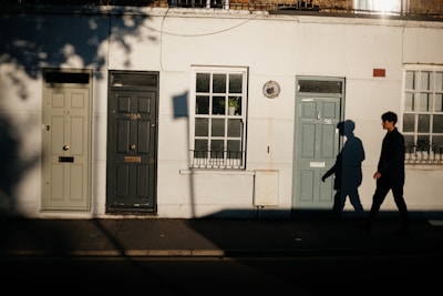 A set of colorful house doors lined up side by side in natural outdoor light.