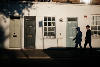 A set of colorful house doors lined up side by side in natural outdoor light.