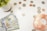 A collection of US currency is spread out on a white surface, including several hundred-dollar bills and a variety of coins. A small potted succulent plant is positioned on the left side, while a pink Himalayan salt candle holder is on the right.