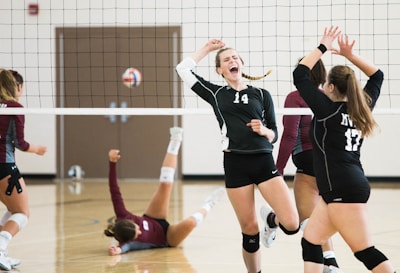 women playing volleyball inside court