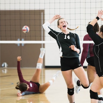 women playing volleyball inside court