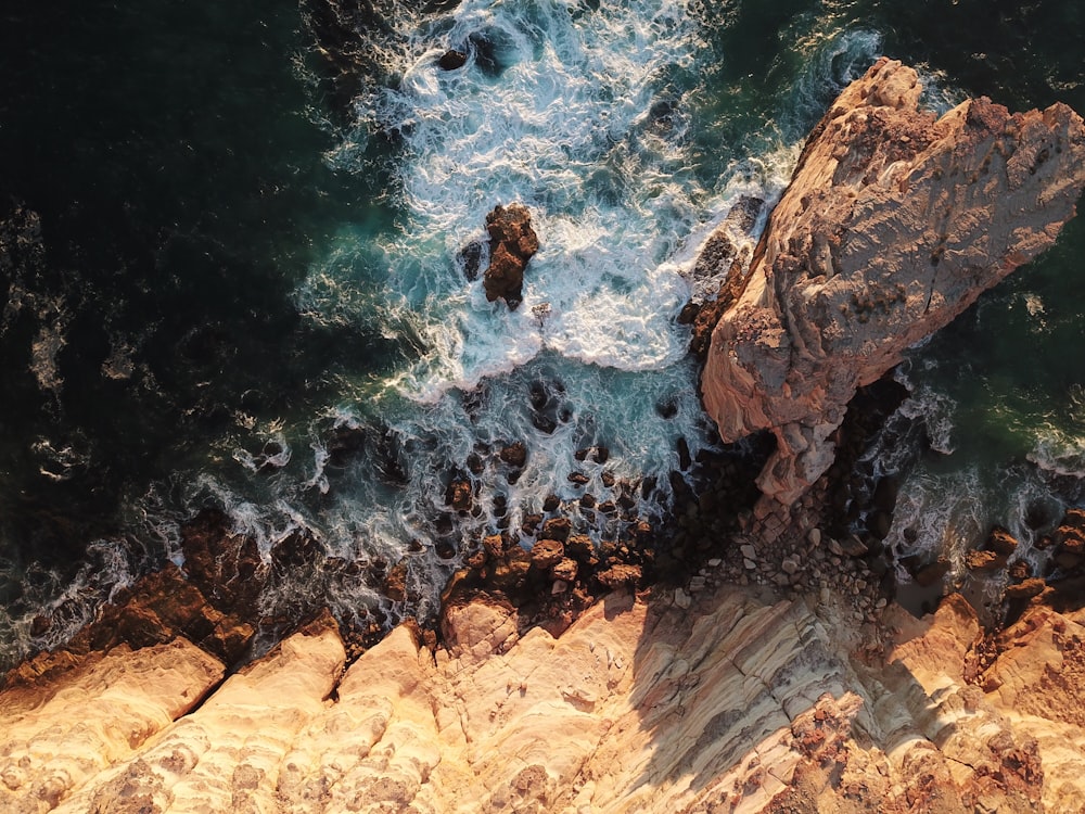 brown rocks on body of water in high-angle view photo