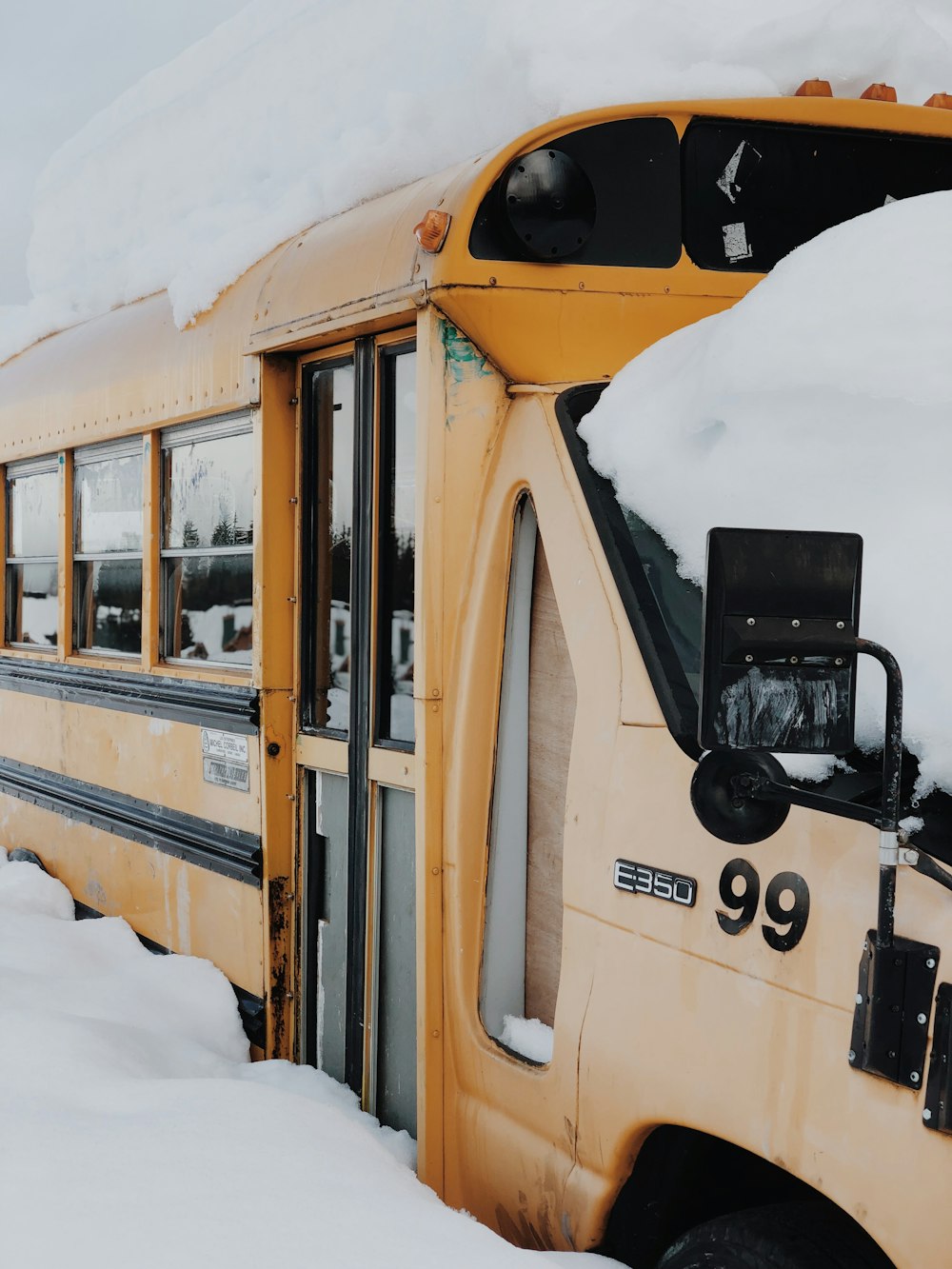 yellow RV on road covered by snow during daytime