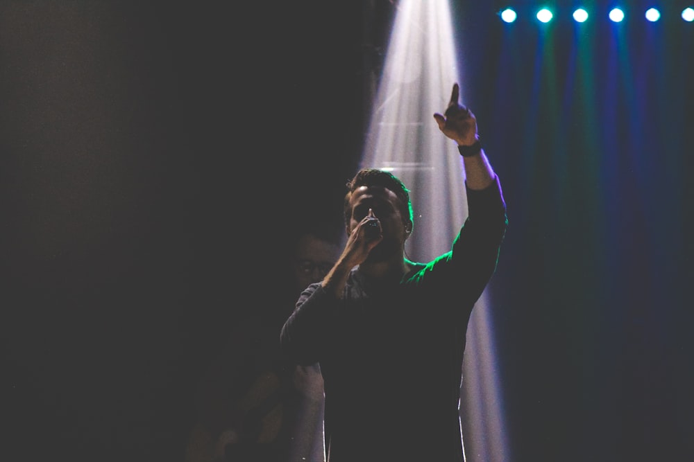 man singing raising hand