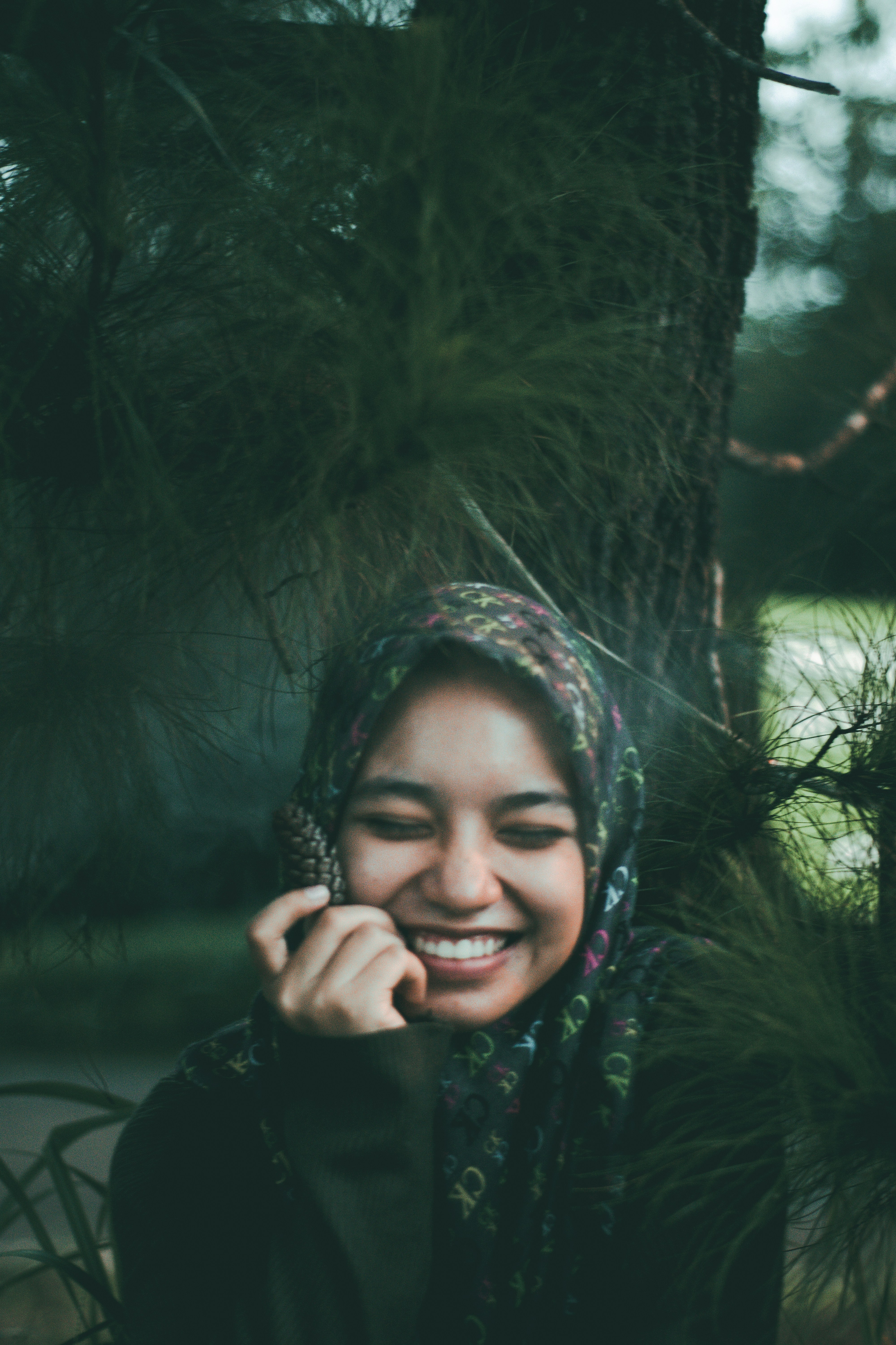 smiling woman standing under tree