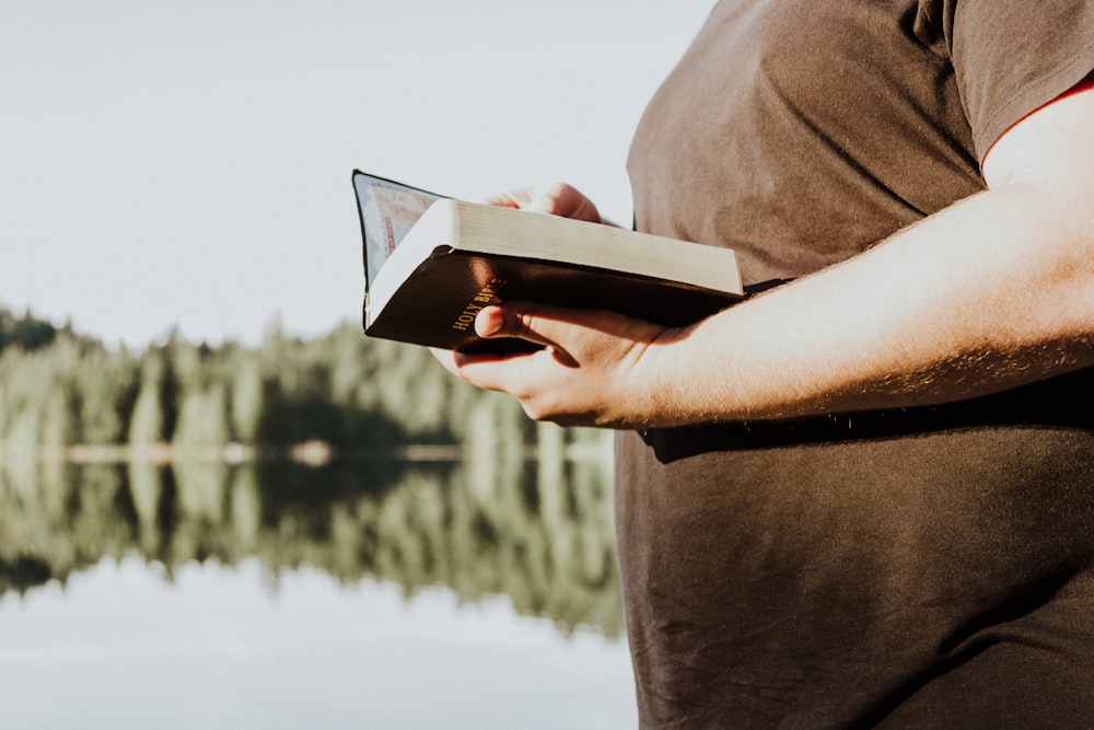 man holding brown book