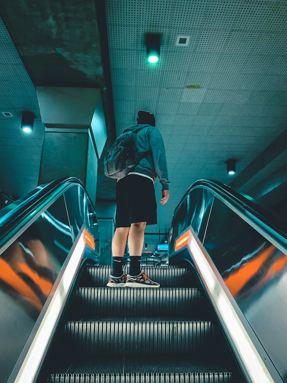 man in jacket standing on escalator