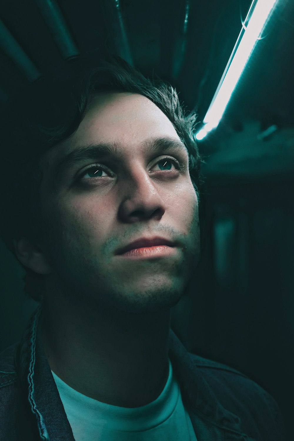 man looking up under lighted lamp