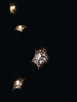 A star-shaped lantern glowing warmly in a dark room, symbolizing Lumi's guiding light.