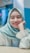 A person wearing a light blue hijab and white blouse, smiling with braces on their teeth. The background is softly blurred with shades of blue and pink.