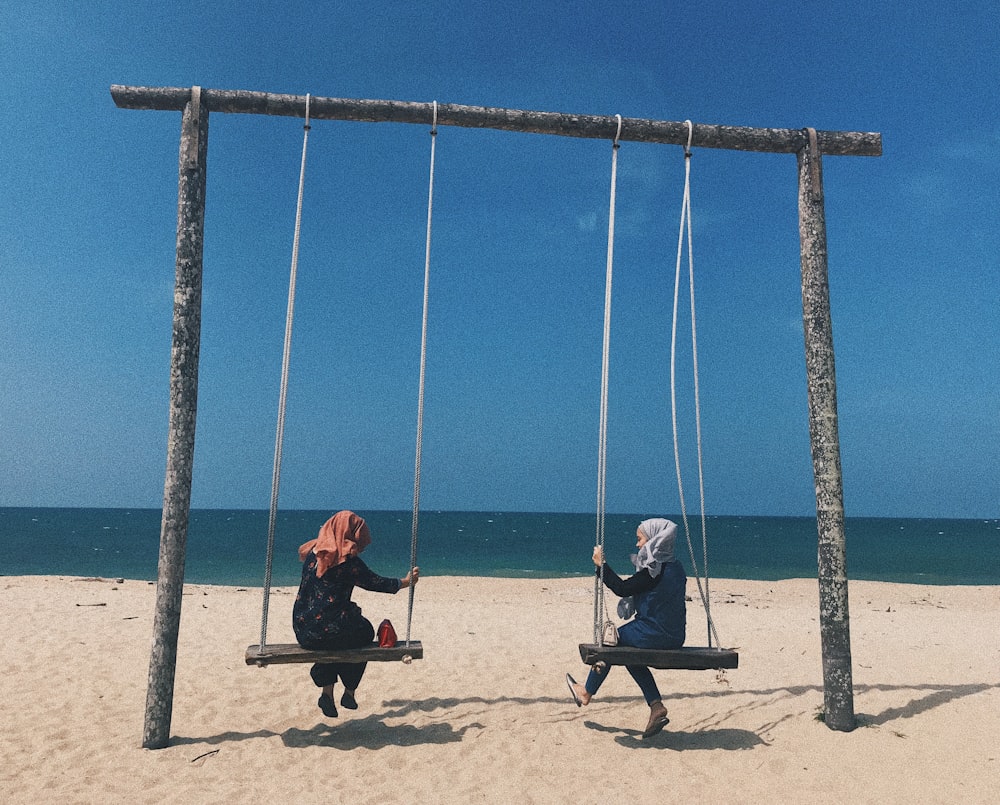 two women swinging during daytime