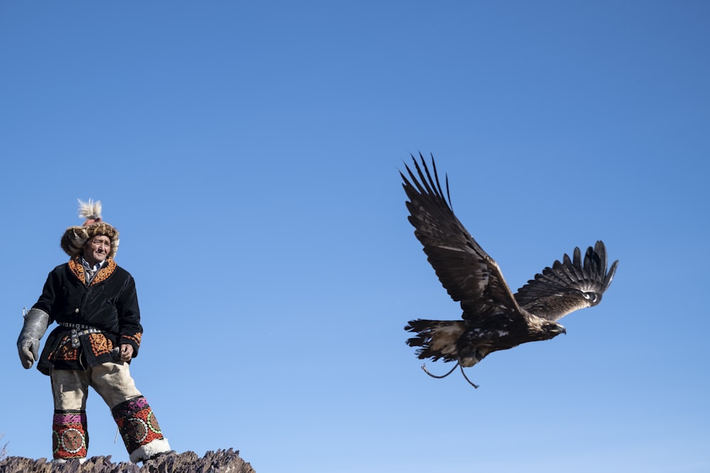 man standing near flying bird