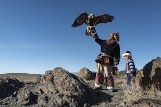 Mongolian man standing while holding eagle