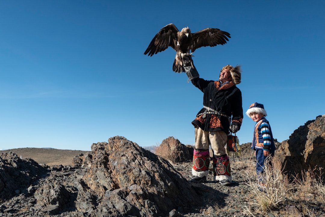 Native American man standing while holding eagle