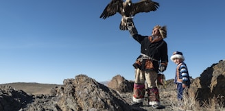 Native American man standing while holding eagle