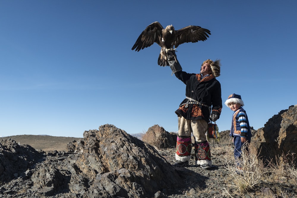 鷲を抱きながら立っているネイティブアメリカンの男性