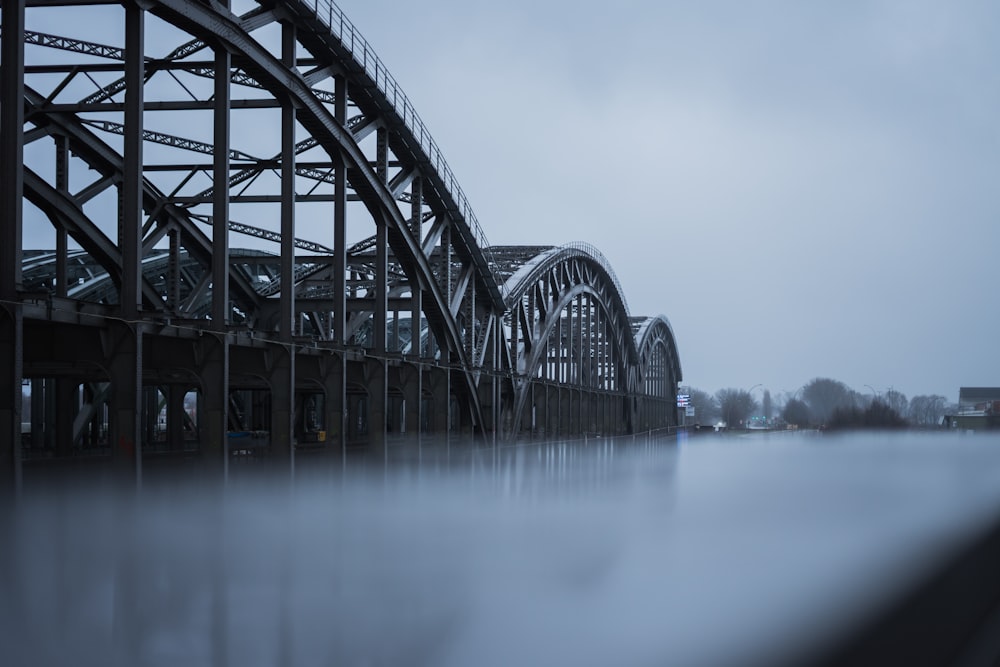 grayscale photography of metal bridge ]