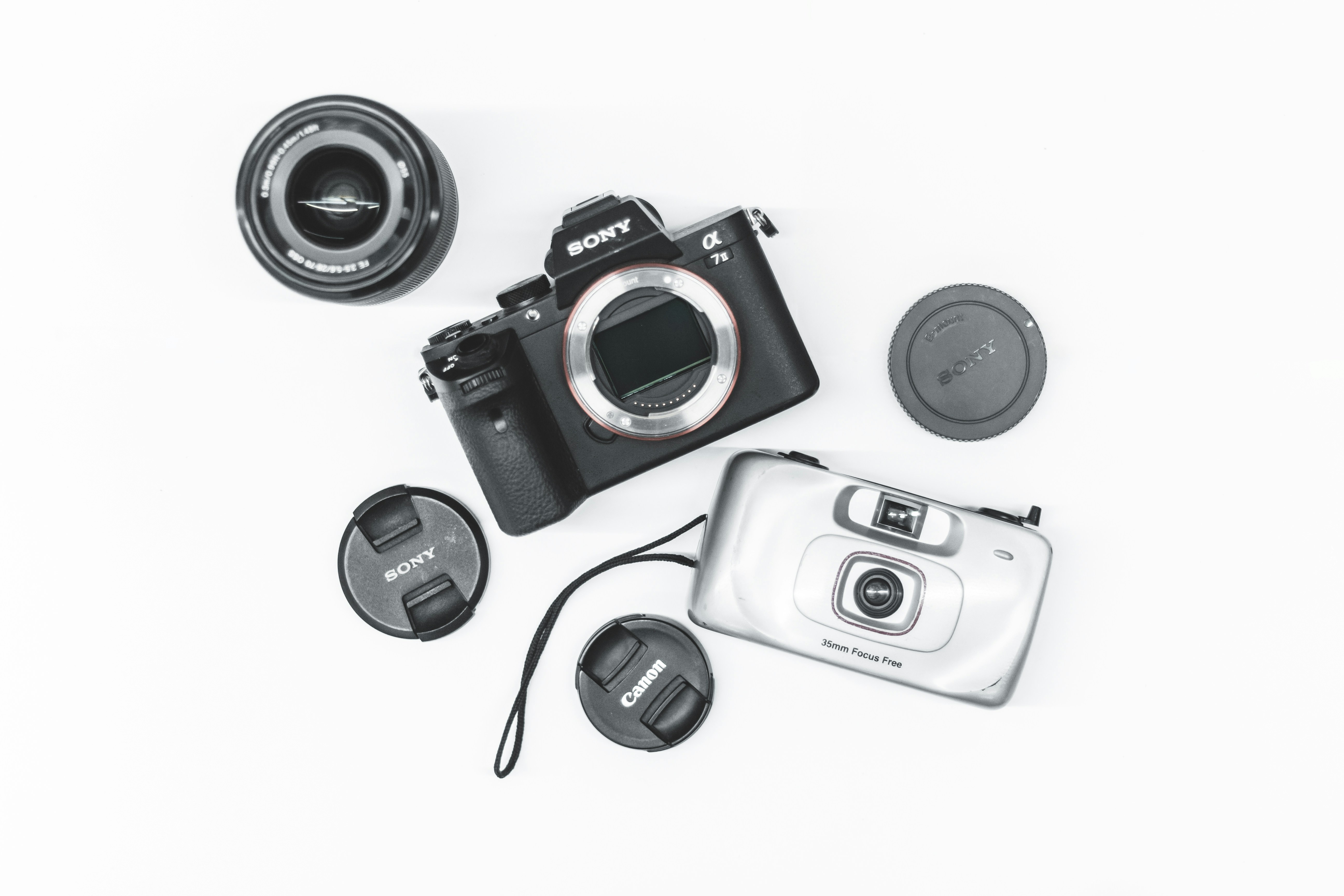 Appareil photo et objectif Sony noir et gris à côté de l’appareil photo standard gris