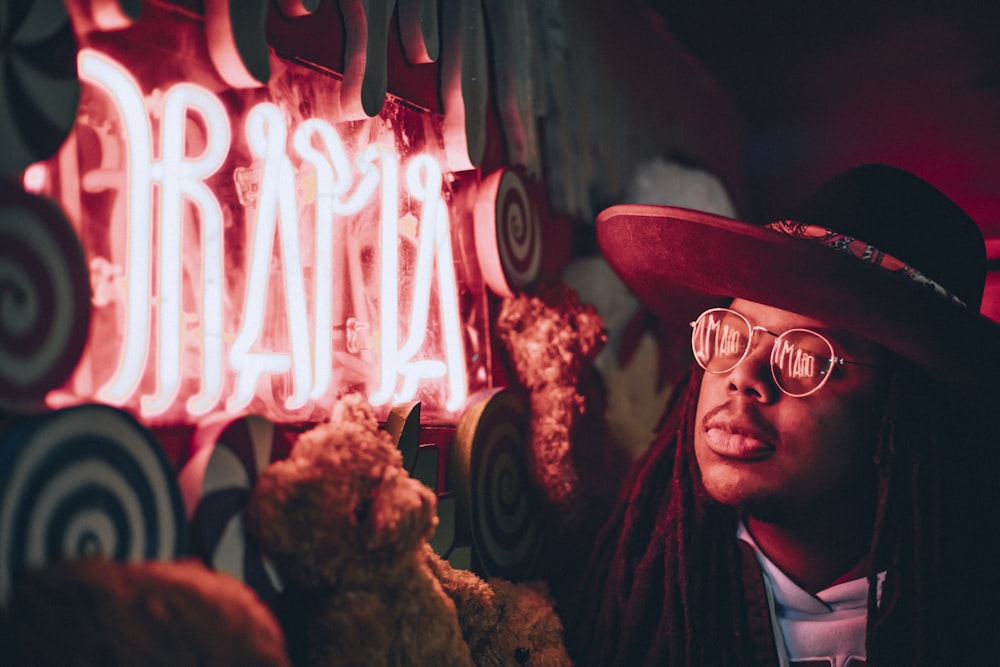 man looking at red neon signage