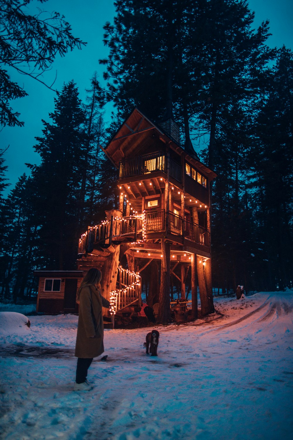 woman in brown coat standing brown house