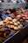 An assortment of beautifully arranged pastries and confections displayed in a bakery setting. The image features cupcakes, donuts, and various chocolates, each decorated with intricate details and toppings. The colors and textures of the sweets create a visually appealing and inviting presentation.