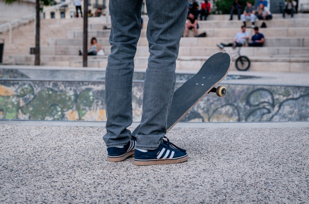 uomo che calpesta lo skateboard sul campo