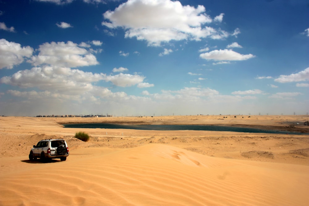 gray SUV on sand dunes during daytime