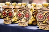 A collection of medals with a dragon design and text indicating 'Brovary 2018 Ukraine Open Championship Kata' displayed on a table. The medals are golden with red details and feature intricate designs.