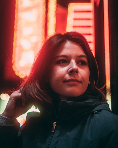 Close-up of a stylish streetwear jacket illuminated by soft neon lighting.