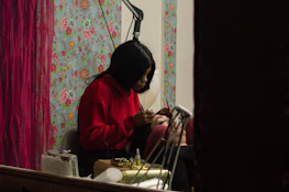 A beautician carefully tinting a client's eyebrows in a cozy, inviting setting.