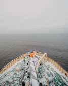 The crew gathered on deck, bundled in warm gear, sharing a moment as the northern lights dance overhead.