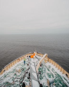 A group of diverse crew members gathered on deck, preparing for departure under clear skies.