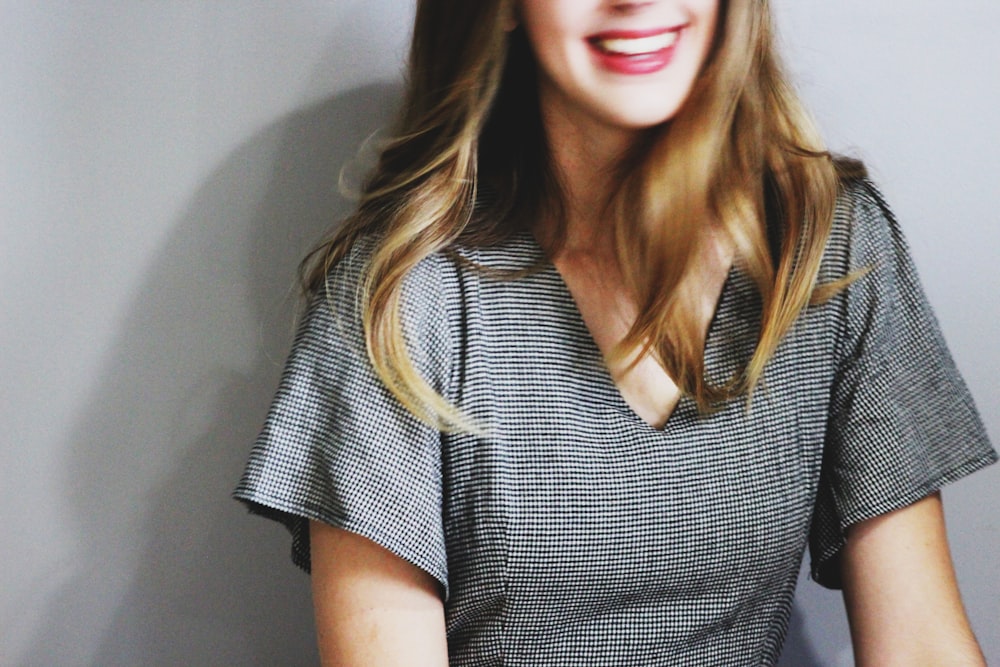 smiling woman wearing gray V-neck blouse