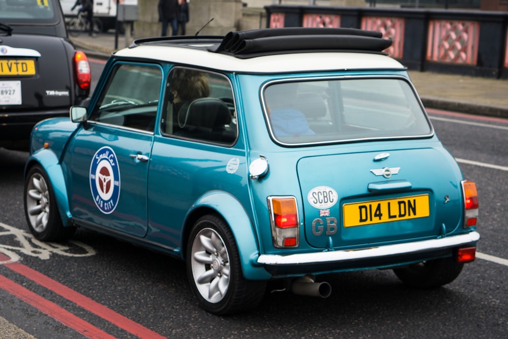 blue and white Mini Cooper on asphalt road