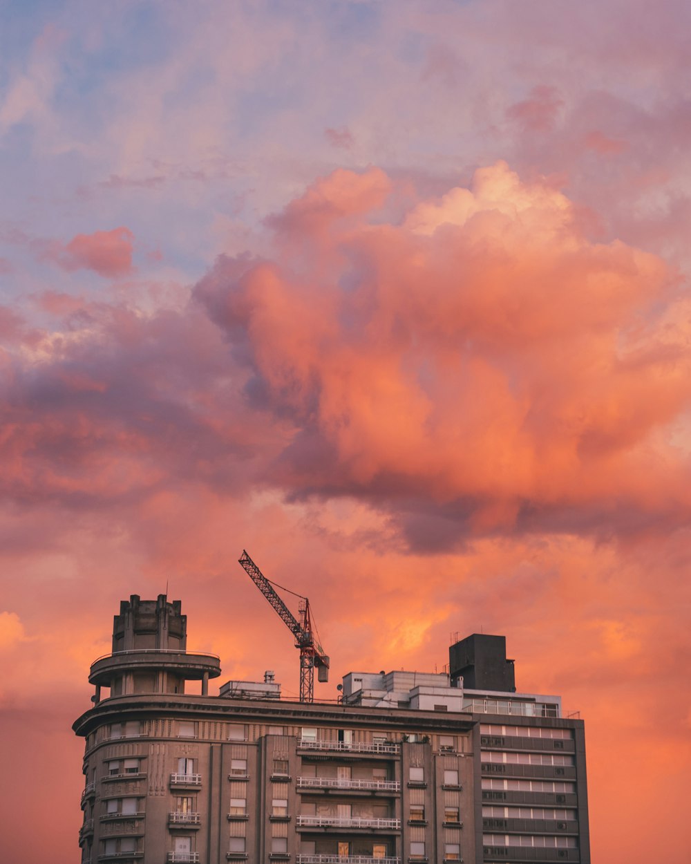 Edifício de concreto marrom e cinza com guindaste de torre cinza