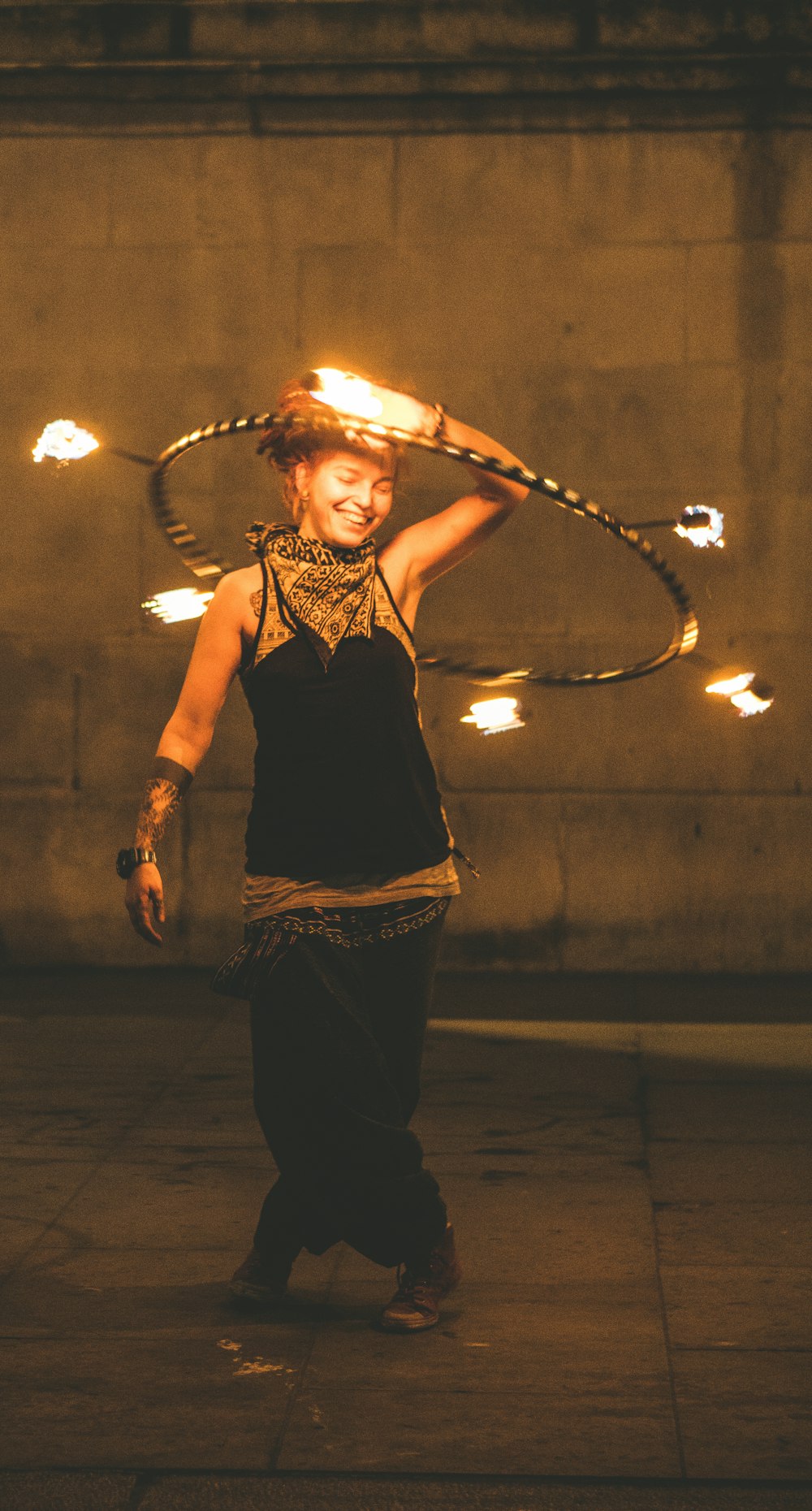 girl wearing black and gold kameez holding hoop with fire