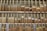 A neatly organized display of cigars in a wooden rack, with various brands and labels visible on the cigars. Each compartment contains an array of cigars, showing diverse shades of brown and different sizes. The setting suggests a retail environment for cigar enthusiasts.