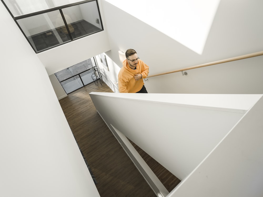 man wearing yellow pullover hoodie climbing on stairs
