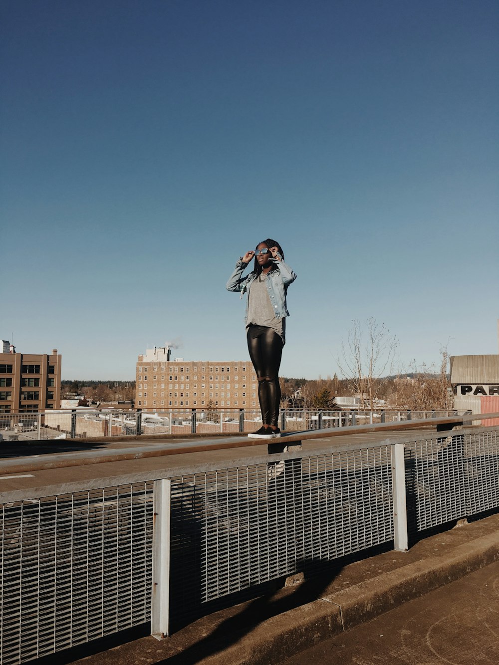 woman standing on fence during daytime