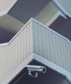 A modern security camera mounted on a residential building exterior.