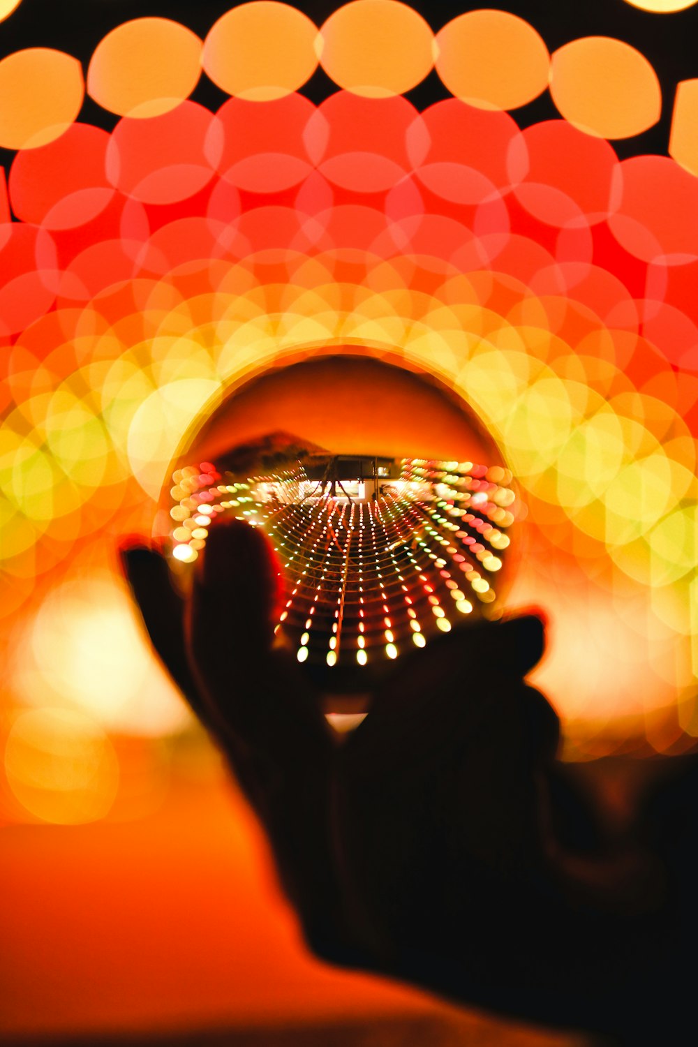 ball on person's hand reflecting light at night time