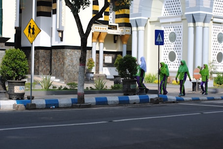 A diverse group of women medical couriers in green and blue uniforms preparing packages for delivery.