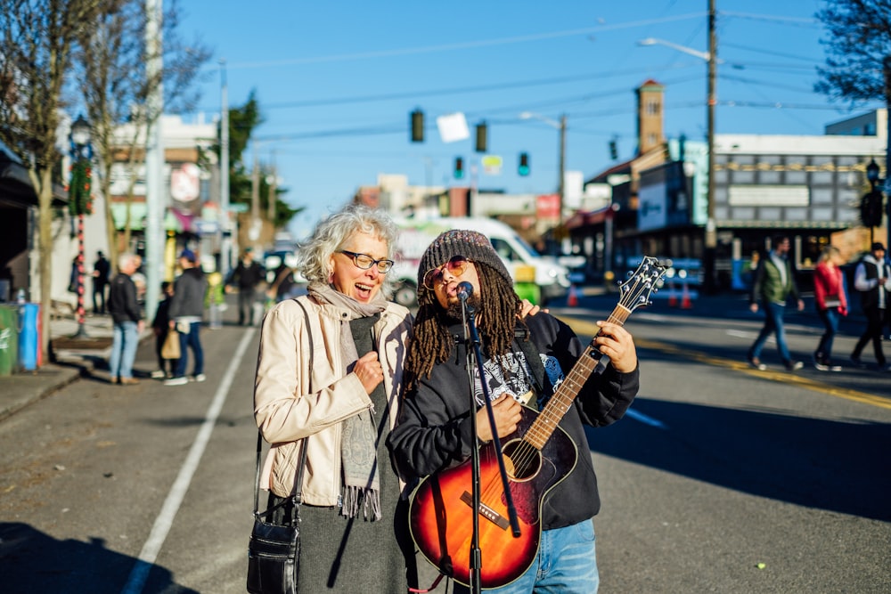 selective focus photo of two women sitting near gray pavement road