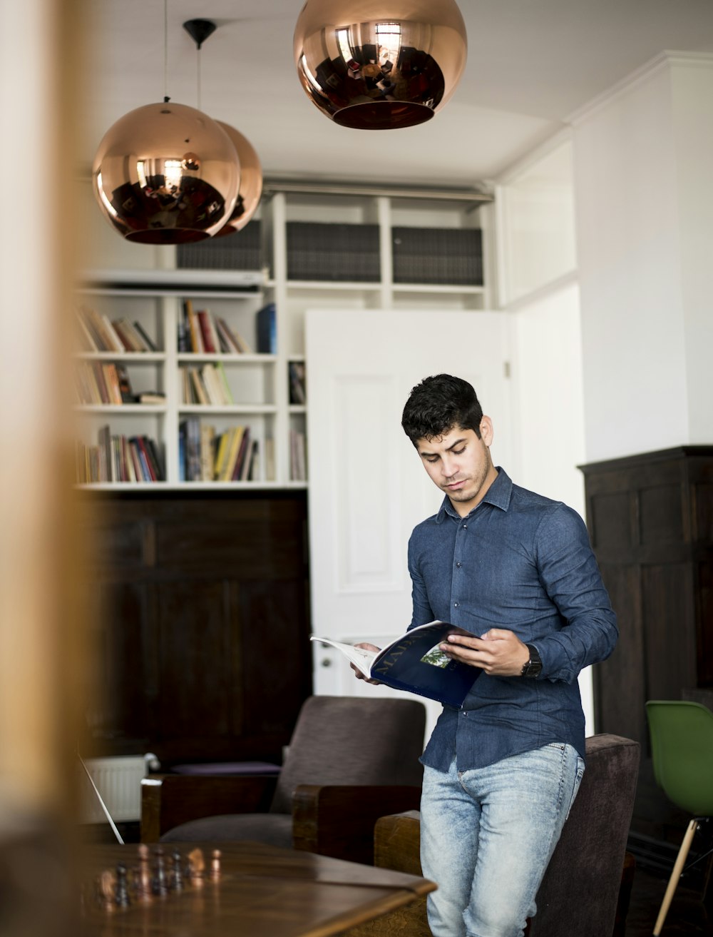 man reads while leaning on the chair