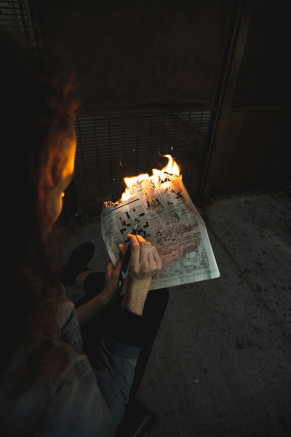 person burning newspaper page