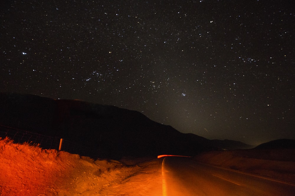 silhouette photography of mountain and stars at night time