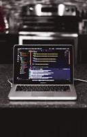 Close-up of hands coding AI algorithms on a laptop with Summit Bridge Solutions branding.