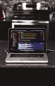 Close-up of hands typing on a laptop with kitchen hardware images on screen.