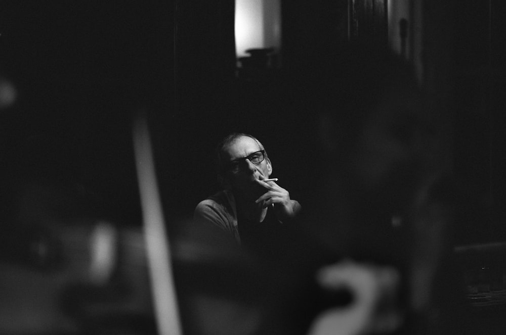 grayscale photography of man smoking